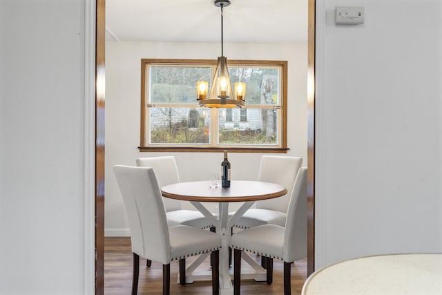 dining area with wood-type flooring and a chandelier