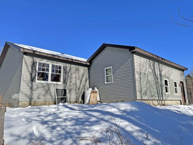 view of snow covered back of property