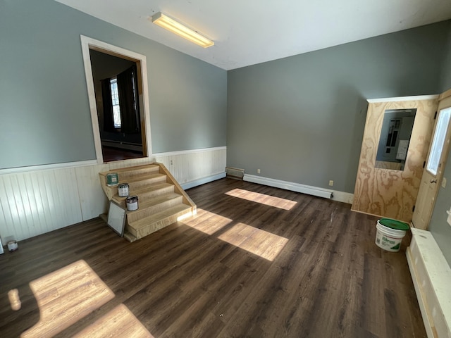 unfurnished room featuring a baseboard heating unit, electric panel, and dark hardwood / wood-style flooring