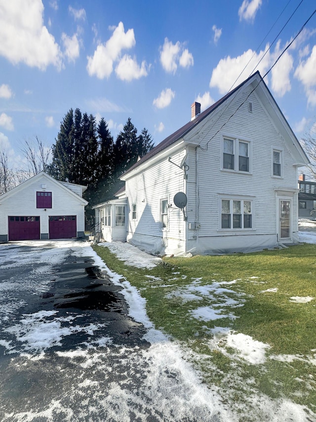 view of front of property featuring a garage and an outdoor structure