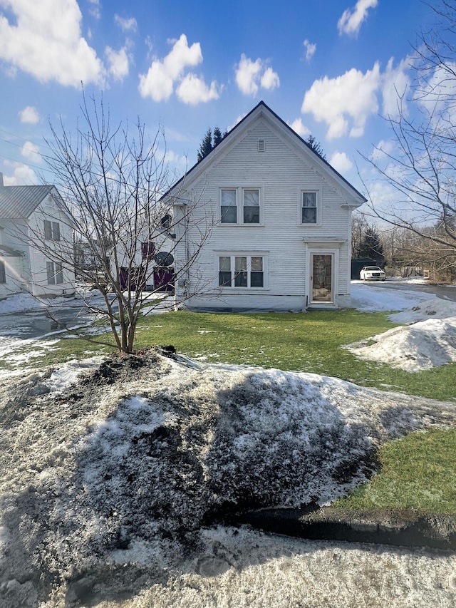 rear view of property featuring a yard