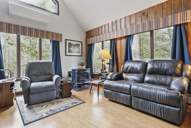 417 Middle Rd, Falmouth, ME 04105 - living area featuring a wall mounted AC, wood finished floors, a wood stove, and high vaulted ceiling