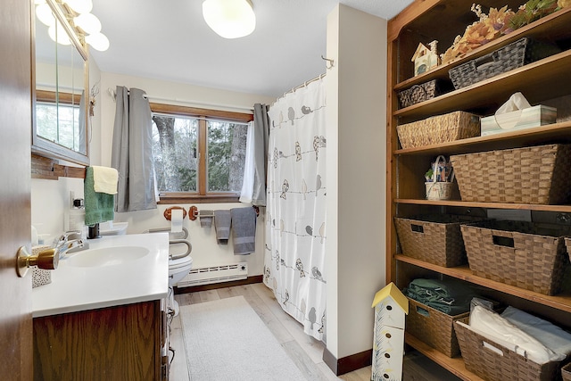 417 Middle Rd, Falmouth, ME 04105 - bathroom with a baseboard radiator, wood finished floors, a wealth of natural light, and vanity