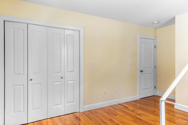 unfurnished bedroom with hardwood / wood-style floors and a closet