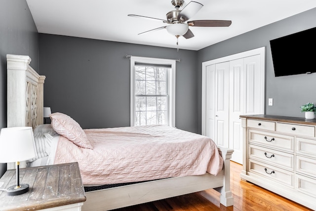 bedroom with ceiling fan, wood-type flooring, and a closet