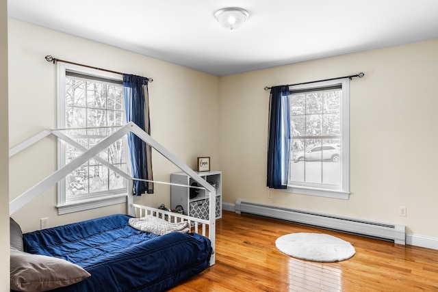 bedroom with hardwood / wood-style flooring and a baseboard radiator