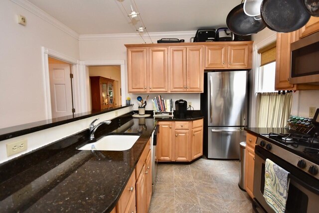 kitchen featuring dark stone countertops, sink, crown molding, and stainless steel appliances