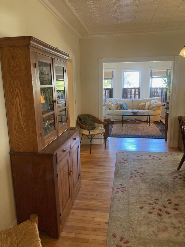 corridor with crown molding and light hardwood / wood-style floors