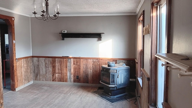 7 Hidden Meadow Ln, Dixfield, ME 04224 - interior space with a wood stove, crown molding, a wainscoted wall, and wood finished floors