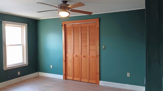 7 Hidden Meadow Ln, Dixfield, ME 04224 - unfurnished bedroom featuring crown molding, ceiling fan, a closet, wood finished floors, and baseboards