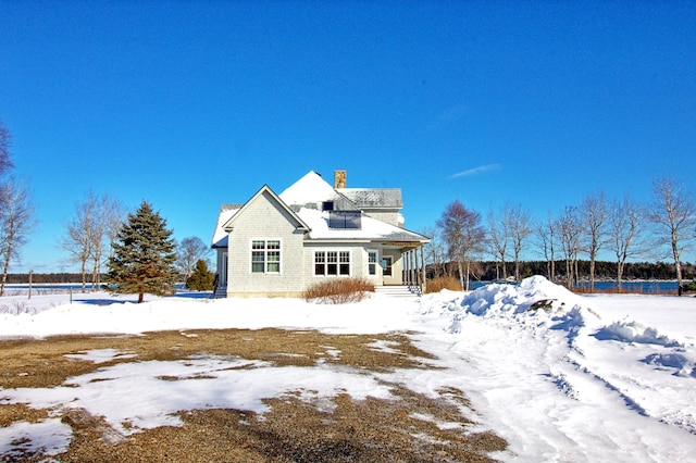 view of snow covered back of property