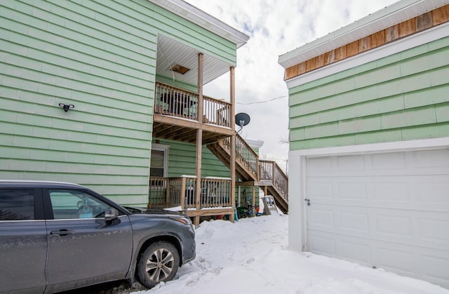 view of snow covered exterior featuring a garage