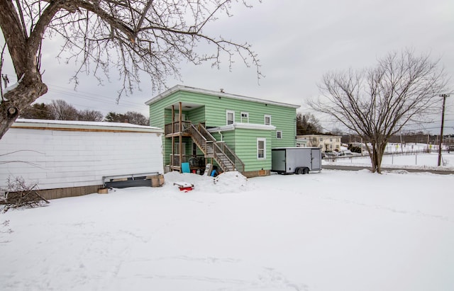 view of snow covered back of property