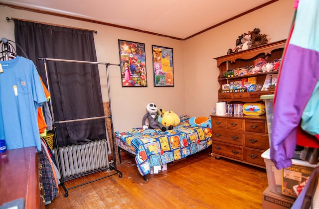 bedroom featuring hardwood / wood-style flooring, crown molding, and radiator