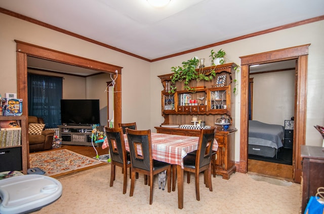 carpeted dining space with ornamental molding