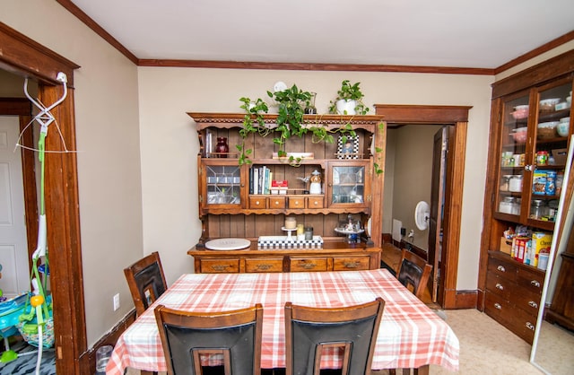 carpeted dining area featuring crown molding