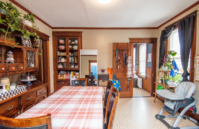 dining space featuring ornamental molding and radiator