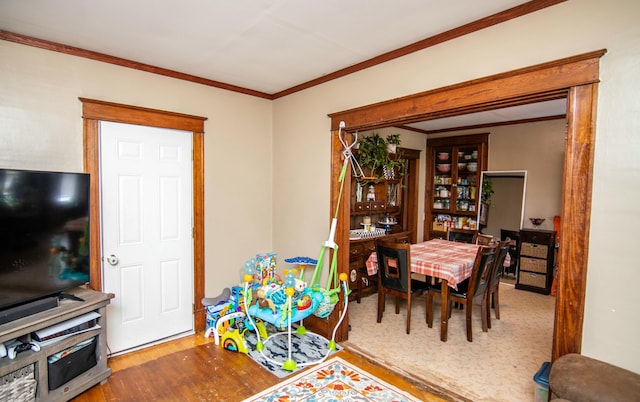 dining space featuring wood-type flooring and ornamental molding