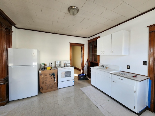 kitchen with white appliances, ornamental molding, sink, and white cabinets