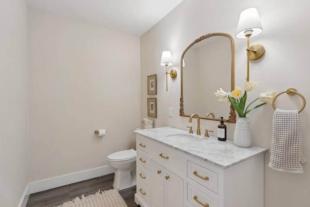 bathroom with hardwood / wood-style flooring, vanity, and toilet