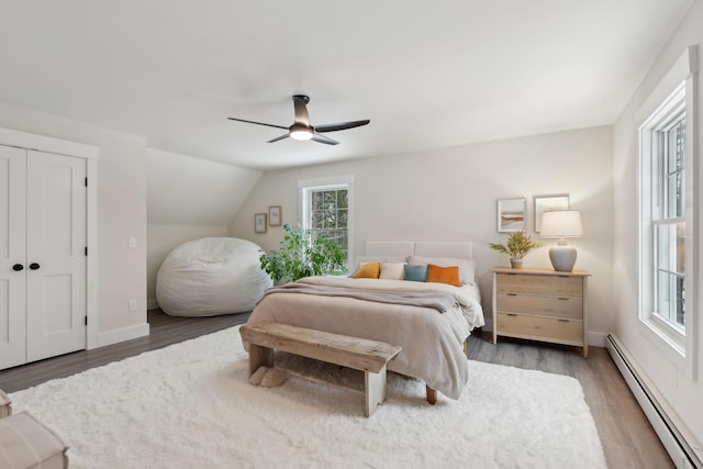 bedroom with ceiling fan, a baseboard radiator, lofted ceiling, and dark hardwood / wood-style flooring