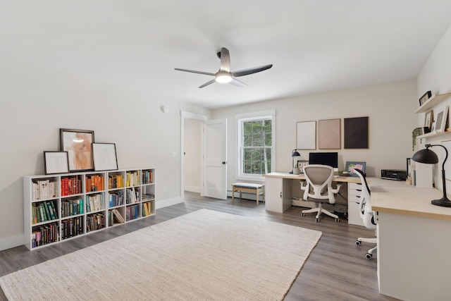 office area featuring a baseboard heating unit, hardwood / wood-style flooring, and ceiling fan