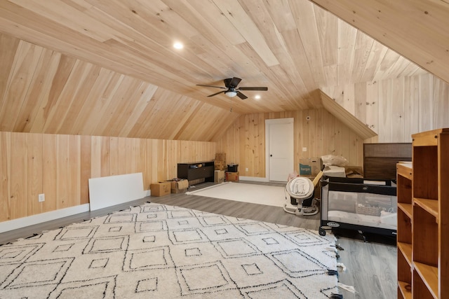 bonus room featuring wooden walls, vaulted ceiling, and light wood-type flooring