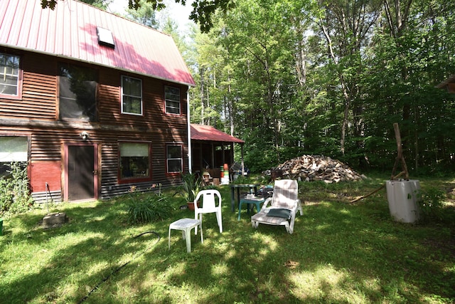 rear view of property featuring a lawn