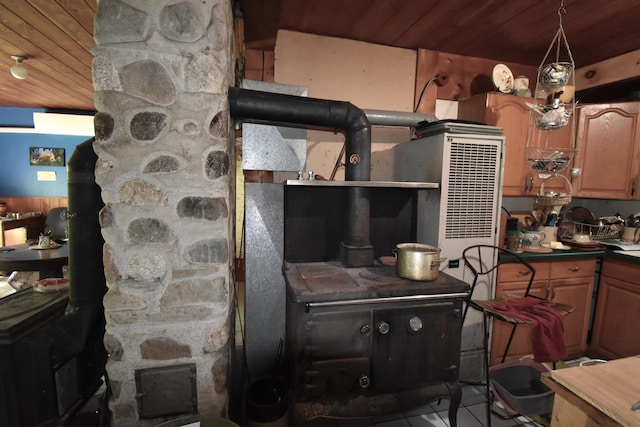 kitchen featuring wooden ceiling, light tile patterned floors, and a wood stove