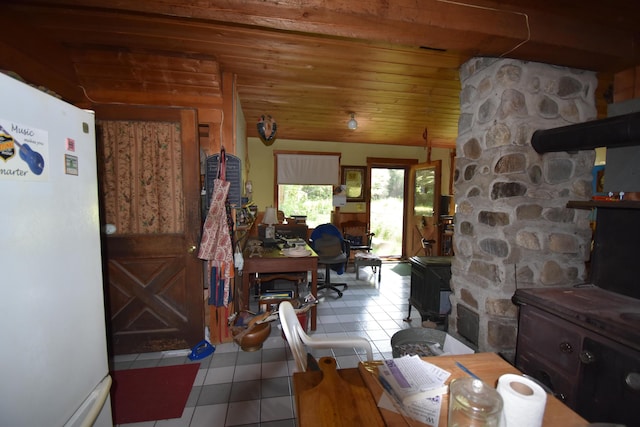 tiled dining space featuring vaulted ceiling and wooden ceiling