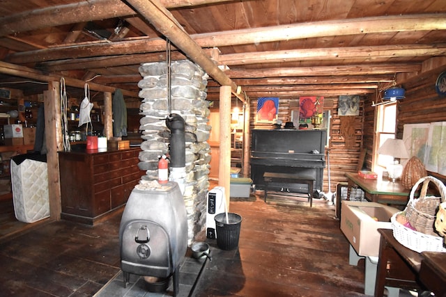 interior space featuring dark hardwood / wood-style flooring, wooden ceiling, and a wood stove