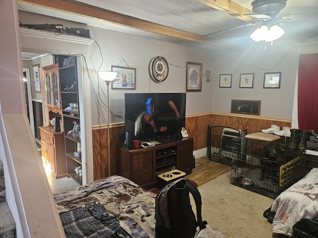 bedroom featuring ceiling fan and wooden walls