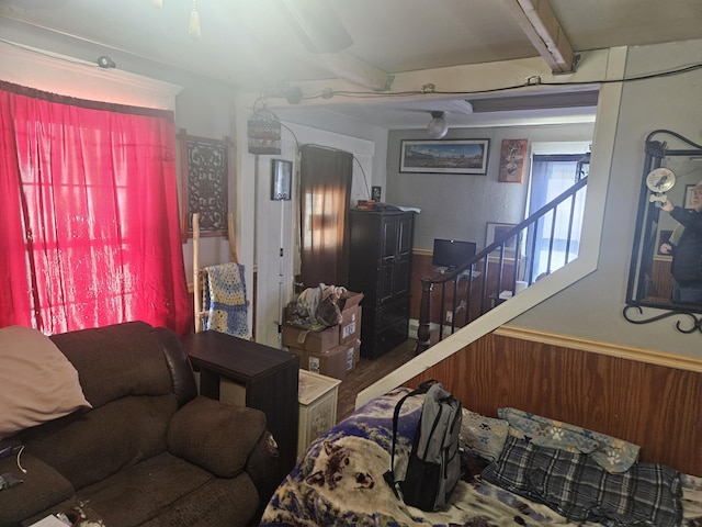 living room featuring beamed ceiling and wooden walls