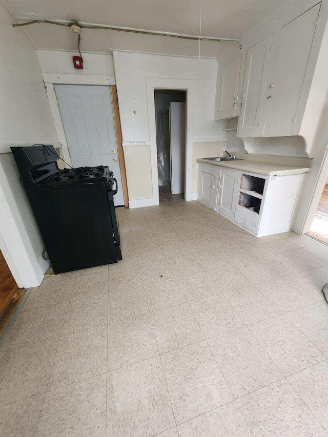 52 Hampshire St, Auburn, ME 04210 - kitchen with sink, washer / dryer, and white cabinets