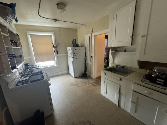 52 Hampshire St, Auburn, ME 04210 - kitchen featuring white cabinetry, washer / clothes dryer, sink, and white fridge