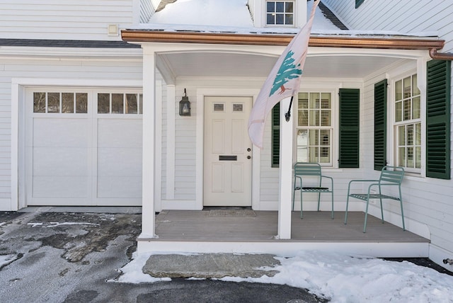 snow covered property entrance with covered porch