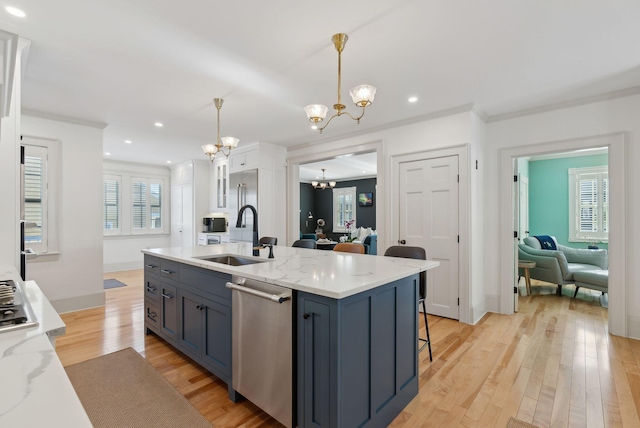 kitchen featuring sink, appliances with stainless steel finishes, white cabinetry, decorative light fixtures, and a chandelier