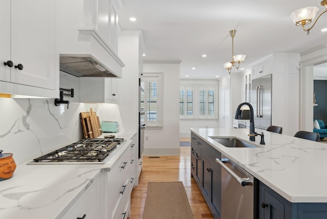 kitchen with hanging light fixtures, white cabinetry, and sink