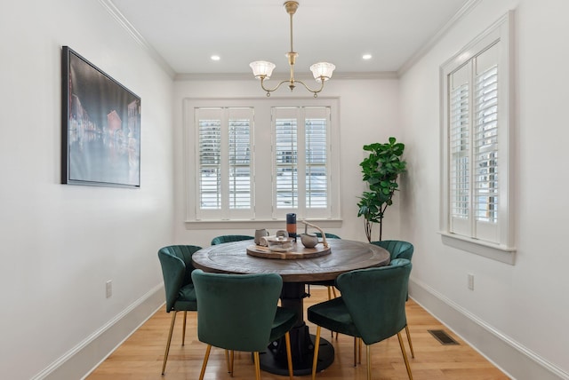 dining room with wood-type flooring, a notable chandelier, and crown molding