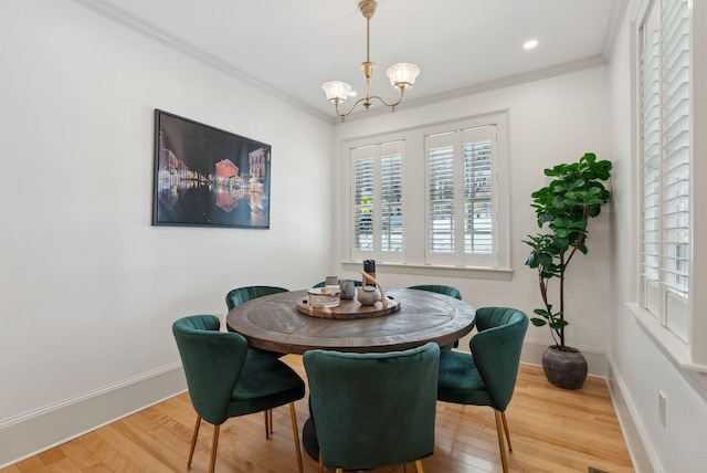 dining area featuring an inviting chandelier, hardwood / wood-style floors, and ornamental molding