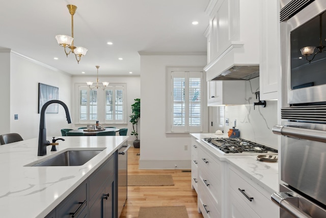 kitchen with sink, decorative light fixtures, a notable chandelier, light stone countertops, and white cabinets