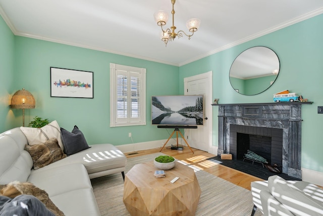 living room with hardwood / wood-style flooring, a high end fireplace, ornamental molding, and a chandelier