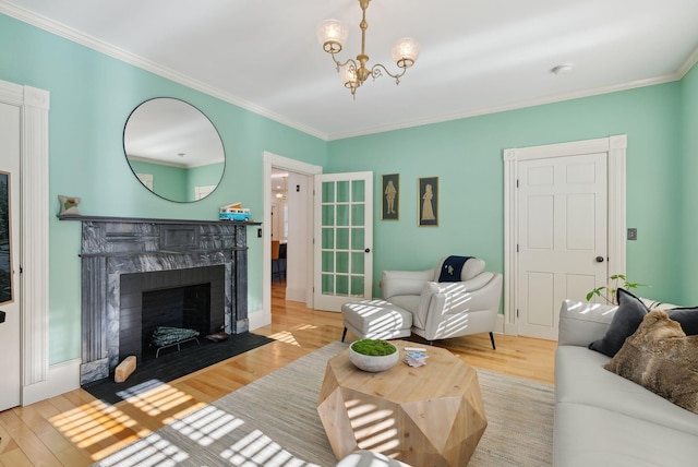 living room featuring crown molding, a fireplace, and light hardwood / wood-style flooring