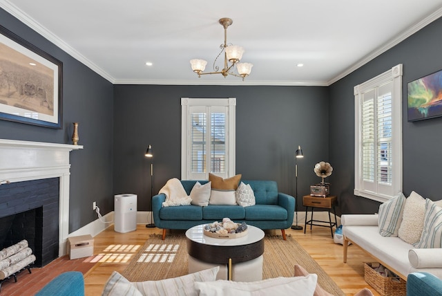 living room featuring ornamental molding, an inviting chandelier, a fireplace, and light hardwood / wood-style floors