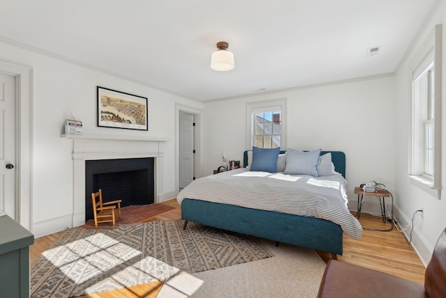 bedroom with ornamental molding and wood-type flooring