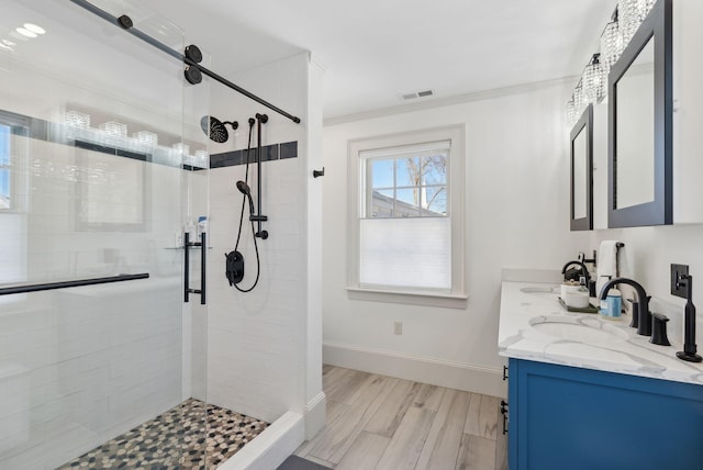 bathroom with crown molding, vanity, a shower with shower door, and hardwood / wood-style flooring