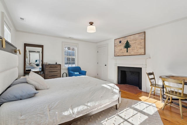 bedroom featuring ornamental molding and hardwood / wood-style floors