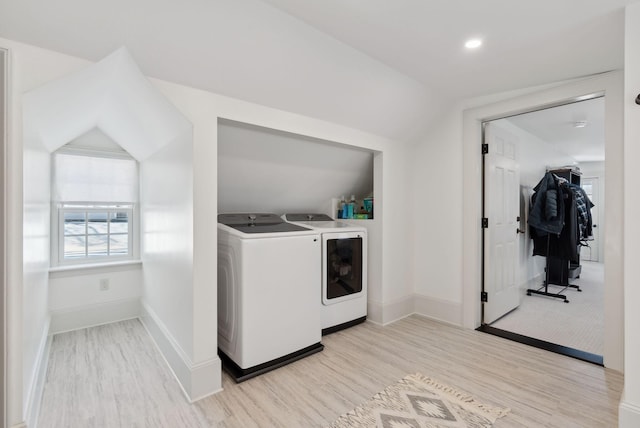 clothes washing area with separate washer and dryer and light hardwood / wood-style flooring