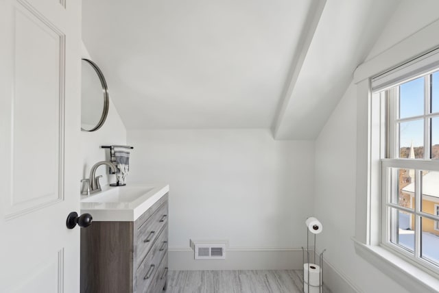 bathroom with lofted ceiling and vanity