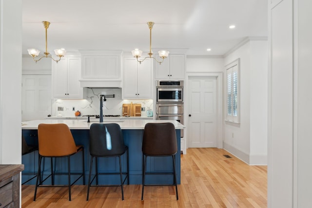 kitchen with white cabinetry, hanging light fixtures, and a chandelier